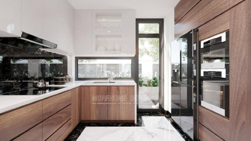 Là một trong những xu hướng trang trí nội thất ấn tượng trong những năm tới, thiết kế phòng bếp hiện đại tôn lên vẻ đẹp mộc mạc nhưng không kém phần sang trọng của gỗ điển hình là gỗ óc chó. Loại gỗ rất được ưa chuộng trong các siêu xe bởi vẻ đẹp ấn tượng từ vân, màu gỗ. Như trong ý tưởng trang trí phòng bếp tại biệt thự Vinhomes Imperia, sự hài hòa tôn lên nét đẹp giữa truyền thống và hiện đại, tủ bếp dưới gỗ óc chó và tủ bếp trên gỗ công nghiệp trắng bóng. Tủ bếp gỗ công nghiệp và tủ bếp acrylic